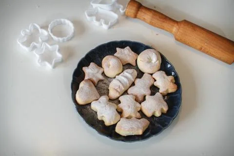 Shortbread on a blue plate on a white background. Rolling pin and cookie cutt Foto stock