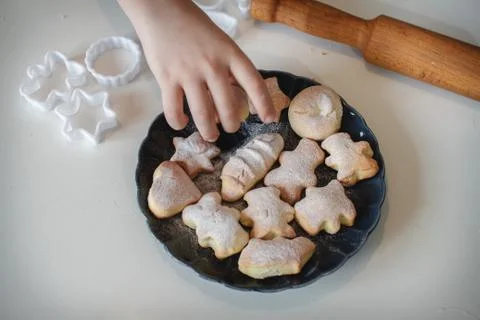 Shortbread on a blue plate on a white background. Rolling pin and cookie cutt Foto stock