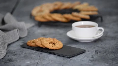 Shortbread cookie ring with peanuts and cup of tea on wooden table. Stock Footage 150433351