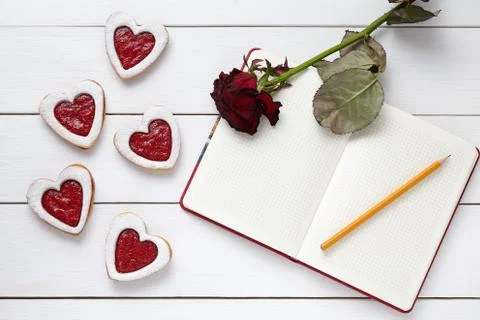 Shortbread heart shaped cookies with empty notebook, pencil and rose flower on Stock Photos