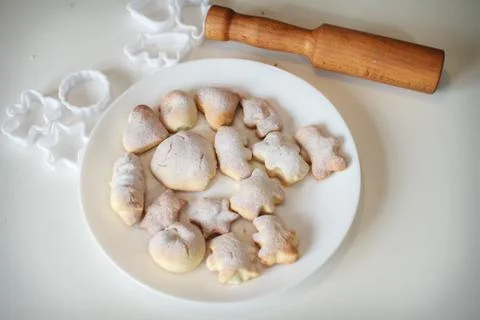 Shortbread on a white plate on a white background. Rolling pin and cookie cut Stock Photos
