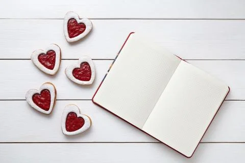 Shortbred heart shaped cookies with empty notebook frame, composition on white Stock Photos