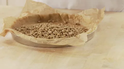 Shortcrust tart base being weighed down with legumes Stock Footage 24642102