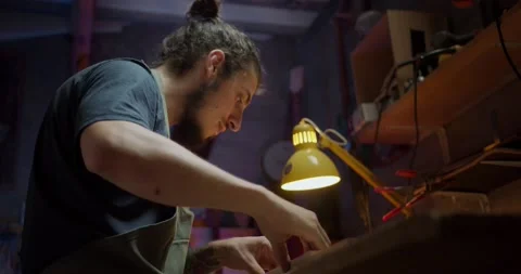 Shot from above of attractive foreman constructing guitar from wood at evening Stock Footage 137241970