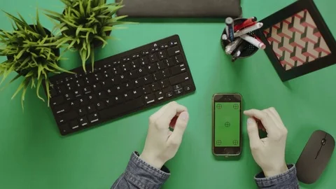 Shot from above of man using smartphone with green screen with chroma key on Stock Footage 81219075
