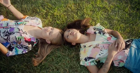 Shot from above of two positive pretty young female laughing having fun on green Video stock 138502842