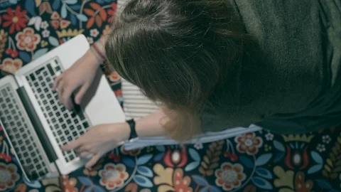 Shot from above of a young woman using the computer lying on the bed 動画素材 128985002