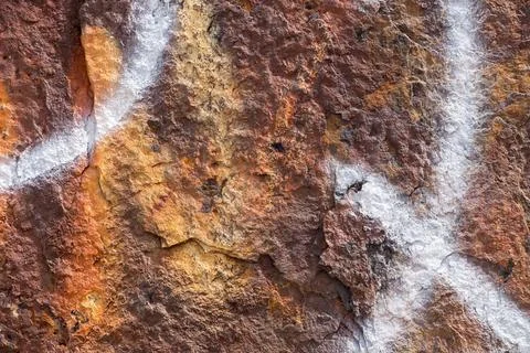 Shot of abstract white patterns and graffiti drawings over a rusty brown surface Stock Illustration