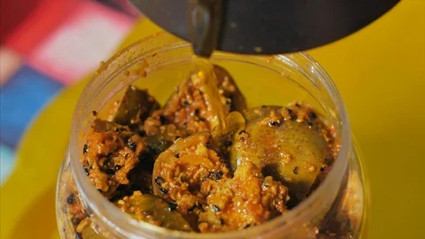 Shot of adding mustard oil into a jar full of fresh mango pickle / achar Stock Footage 117467314