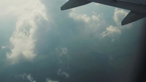 Shot of aerial view above clouds from airplane window with blue sky beautiful Stock Footage 138633700