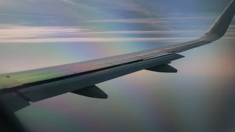 Shot of an airplane wing flying high above the ocean water against a blue sky Stock-Footage 336717574
