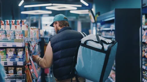 Shot back delivery man in uniform with backpack walking in supermarket look Stock-Footage 143740259
