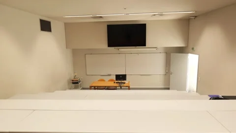 Shot from the back of an empty university classroom looking toward the front Stock Footage 320068960