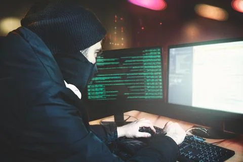 Shot from the Back to Hacker Breaking into Corporate Data Servers from His Un Foto stock