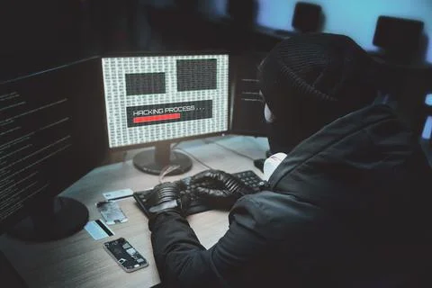 Shot from the Back to Hacker Breaking into Corporate Data Servers from His Un Foto stock