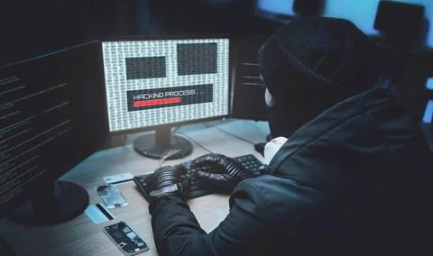 Shot from the Back to Hacker Breaking into Corporate Data Servers from His... Foto stock