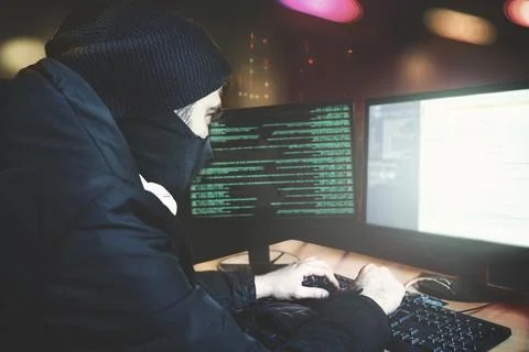 Shot from the Back to Hacker Breaking into Corporate financial Data Servers from Foto stock