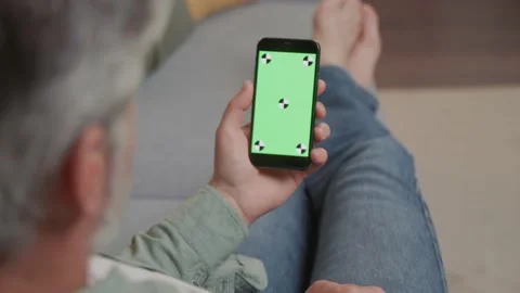 Shot back hands man lying on couch with modern smartphone with mock up green Vídeos de archivo 220202793