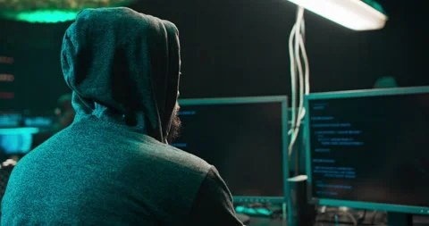 Shot from the Back to Hooded Hacker Breaking into Corporate Data Servers from Stock Footage 146046937