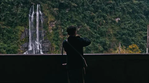 Shot back of Man standing infront of waterfall looking around-Wulai Falls Taipei Stock Footage 271265768