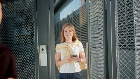 Shot from back of messenger in black uniform passing food delivery to attractive Stock Footage 125465622