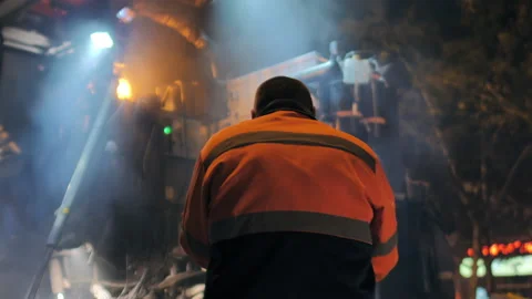 Shot from the back of a road worker in front of an asphalt paver. Steam from hot Stock-Footage 153380227