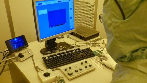 A shot of the back of a scientist working on a big electrone microscope. Vidéo 94570001