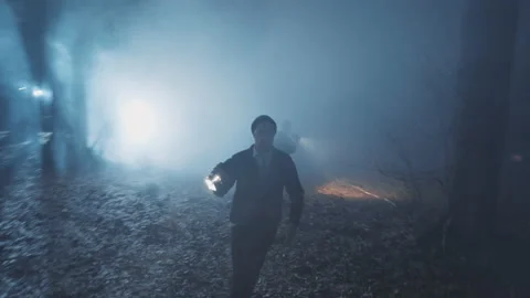 Shot back two detectives young men in woods at night with flashlight. Forest 動画素材 183428353