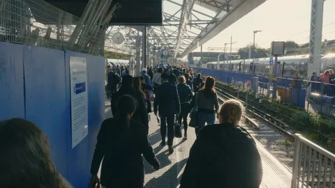 Shot from behind and above of rush hour crowd heading for tube train on platform Stock Footage 88955821