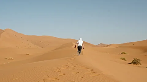 Shot from behind of single man running in slomo on sand dune in Sahara Video stock 279540599