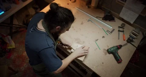 Shot from below of confident master artisan smoothing surface of wooden guitar Video stock 137243644