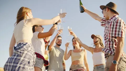 Shot from below, friends joyfully raise their glasses high into the air, make a Stock Footage 286072775