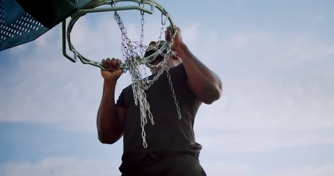 Shot from below of powerful man holding basketball hoop with strong arms on Video stock 123666165
