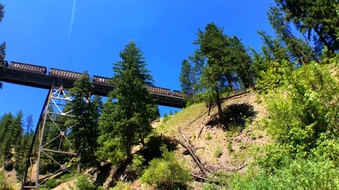 A shot from below of a train passing over a wooden bridge over fish creek Vidéo 94053264
