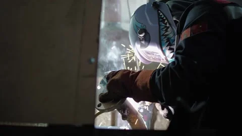 Shot from below, a worker at the factory welds a pipe Stock Footage 157590886