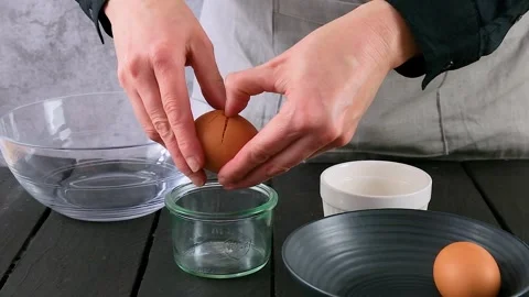 Shot of breaking eggs to separate whites from yolks. Pie maker breaking eggs in  Stock Footage 259516549