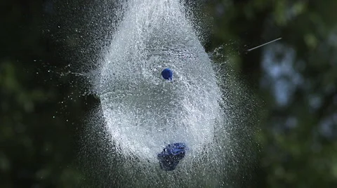 Shot breaking water filled blue balloon, slow motion Stock Footage