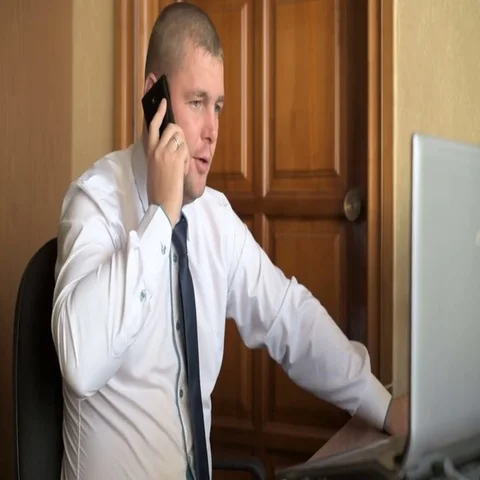 Shot of a businessman using a laptop while talking on mobile Stock Footage 69584032