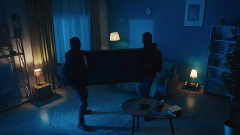 Shot capturing two burglars trying to bring a TV out of the apartment, house 写真素材