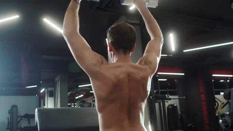 Shot of Caucasian athletic man doing exercise, holding weights in hands in gym Stock Footage 189007935