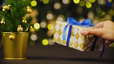 Shot of a Christmas time concept. Small gift box in man hands near decorated Stock Footage 98683965