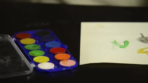 Shot close-up of a child's hand dipping a watercolor brush. Stock Footage 135605162