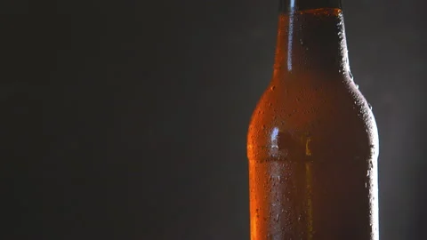 Shot of cold beer bottle with water droplets. on a dark background Stock Footage 100767787