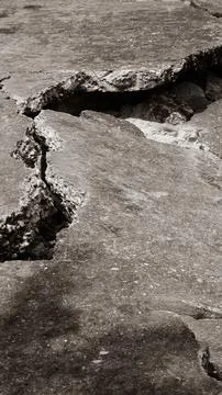 Shot of collapsed concrete layers with a deep hollow void and jagged fissures Stock Photos