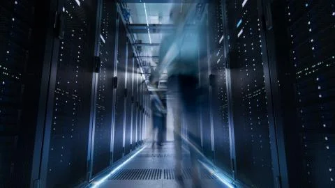 Shot of Corridor in Large Data Center Full of Moving and Working People. Pron Stock Photos