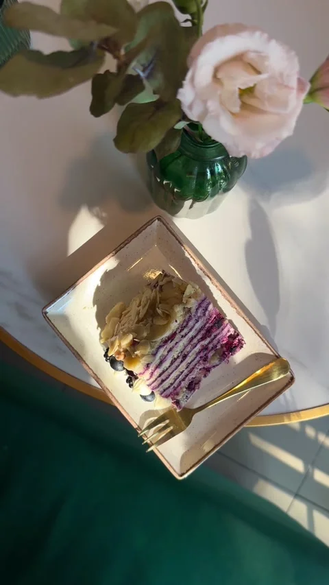 Shot of Delicious Cake Slice and Flower on Table Stock Footage 342133182
