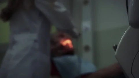 Shot of dentist tools on first plan and patient on background. Stock Footage 128295087