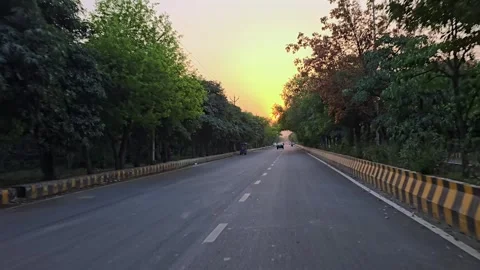 A Shot of Driving on Tree Lined Road at Sunset in Delhi India Vidéo 332886607