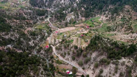 A shot of a drone flying over a beautiful mountain range and a mountain road 4k Stock Footage 213610810