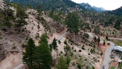A shot of a drone flying over a beautiful mountain range and a mountain road 4k Stock Footage 213612849